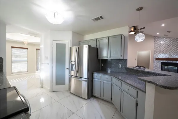 a kitchen with a refrigerator sink and cabinets