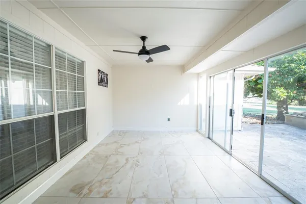 a view of a room with a ceiling fan and window