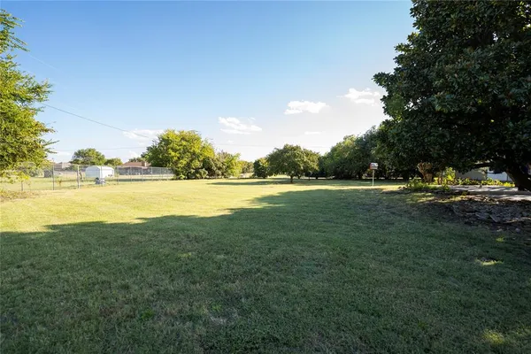 a view of a green field with wooden fence