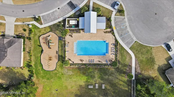 an aerial view of a house with swimming pool and a yard