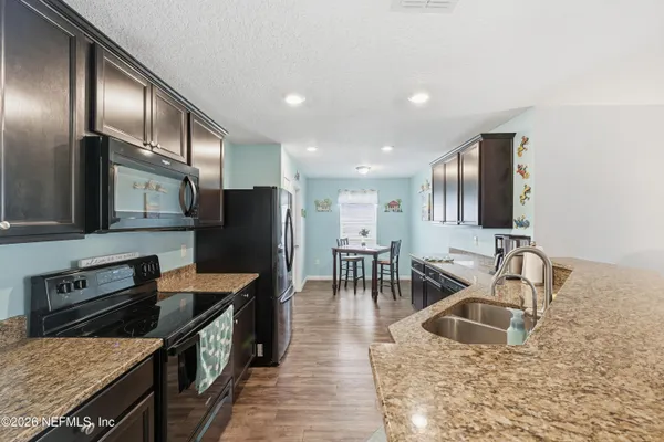 a kitchen with stainless steel appliances granite countertop a sink stove and refrigerator