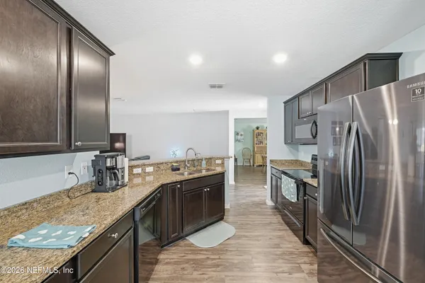 a kitchen with stainless steel appliances granite countertop a sink and a refrigerator