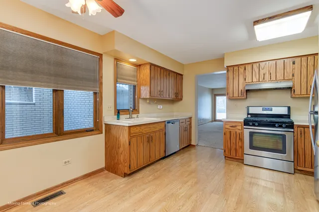 a kitchen with stainless steel appliances granite countertop a stove a sink and a refrigerator