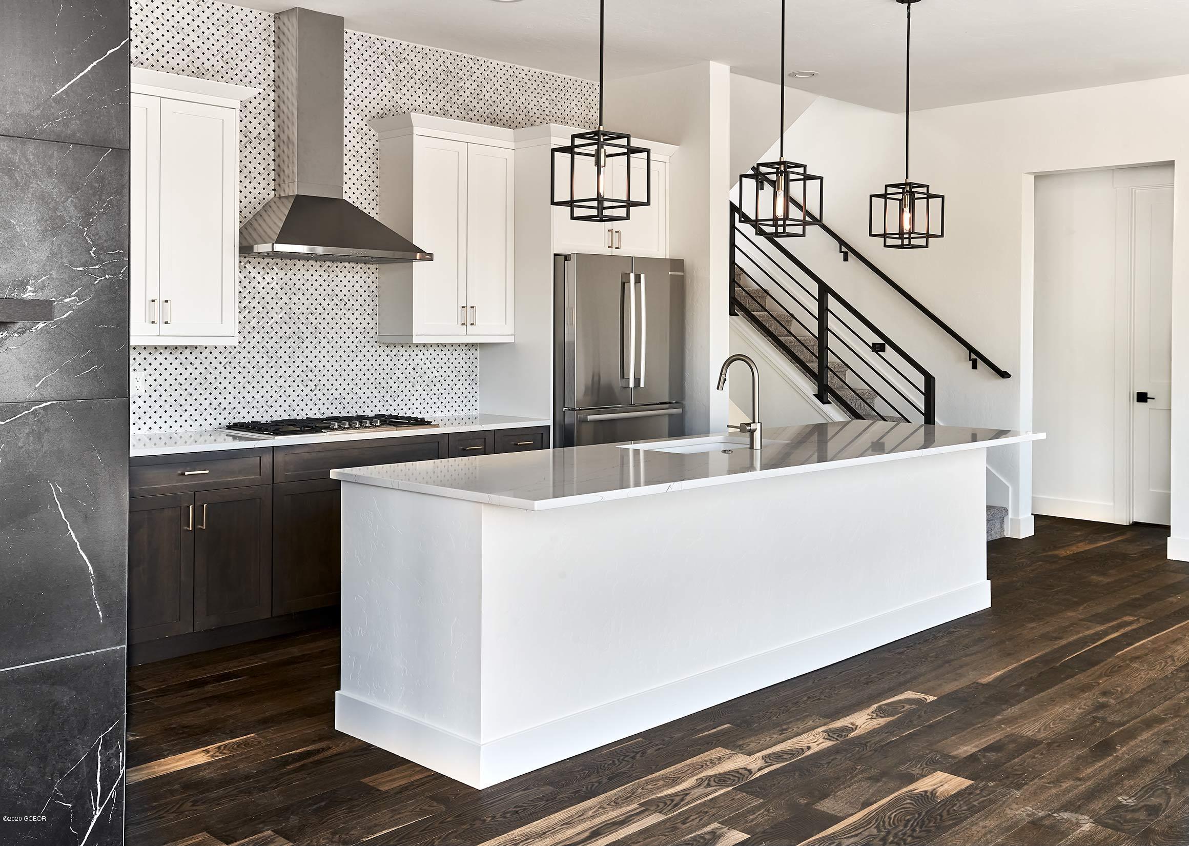 108 Rendezvous Way Winter Park, CO 80482 - Photo 8 of 16 a kitchen with stainless steel appliances granite countertop a sink a stove and a wooden floor