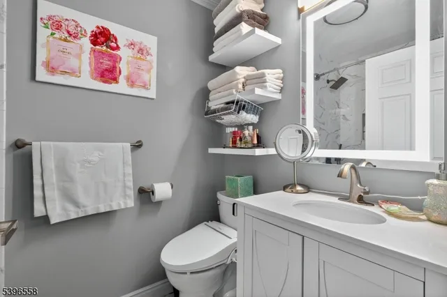 a bathroom with a sink mirror vanity and toilet