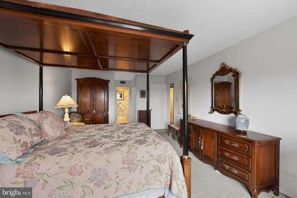 a bedroom with a bed and a mirror on dresser
