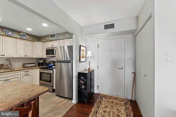 a kitchen with stainless steel appliances granite countertop a refrigerator and a stove top oven