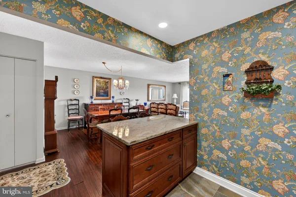 a living room with stainless steel appliances granite countertop furniture and a rug