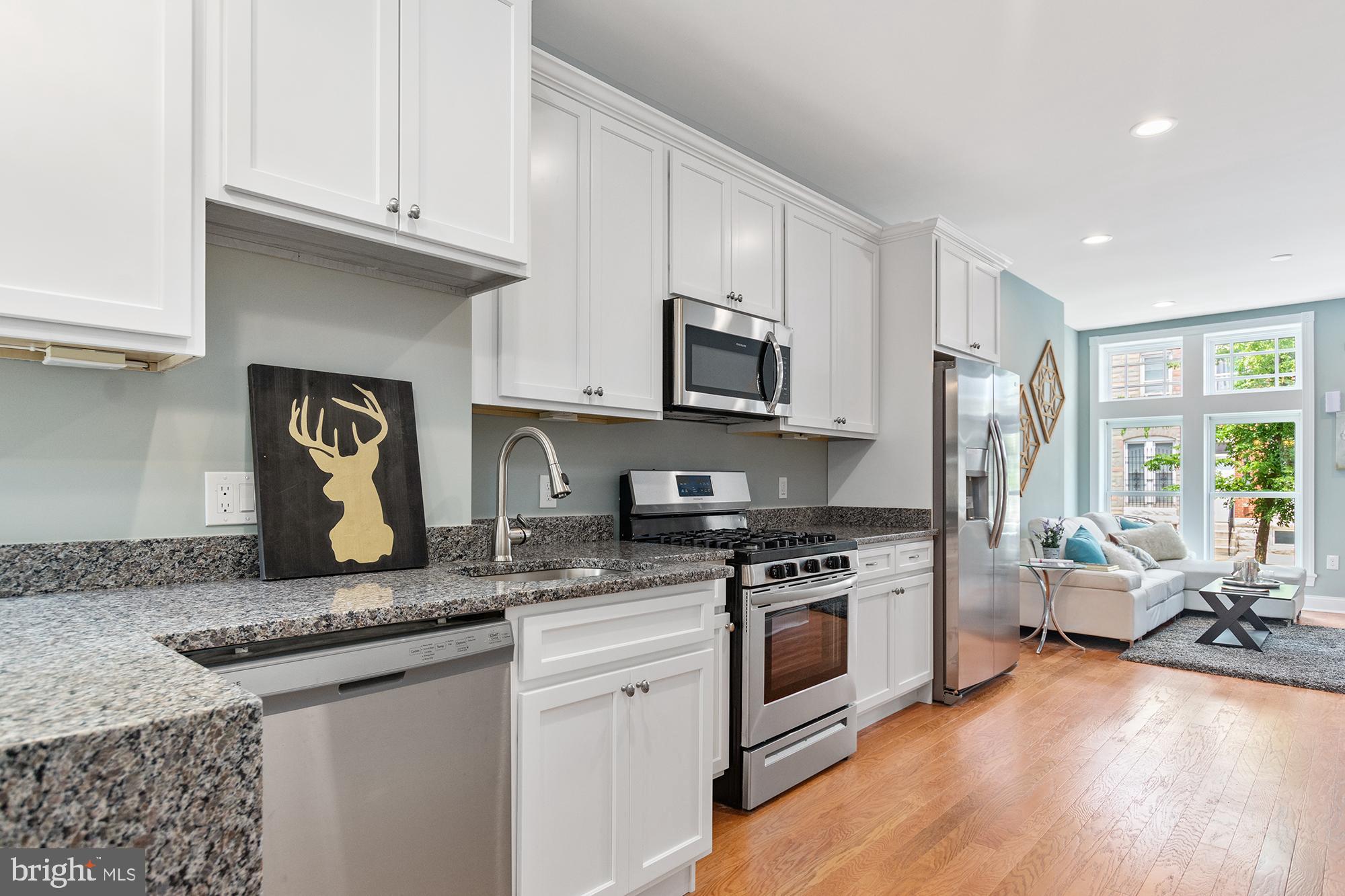 1433 Federal Street Baltimore, MD 21213 - Photo 2 of 9 a kitchen with granite countertop a stove sink and cabinets