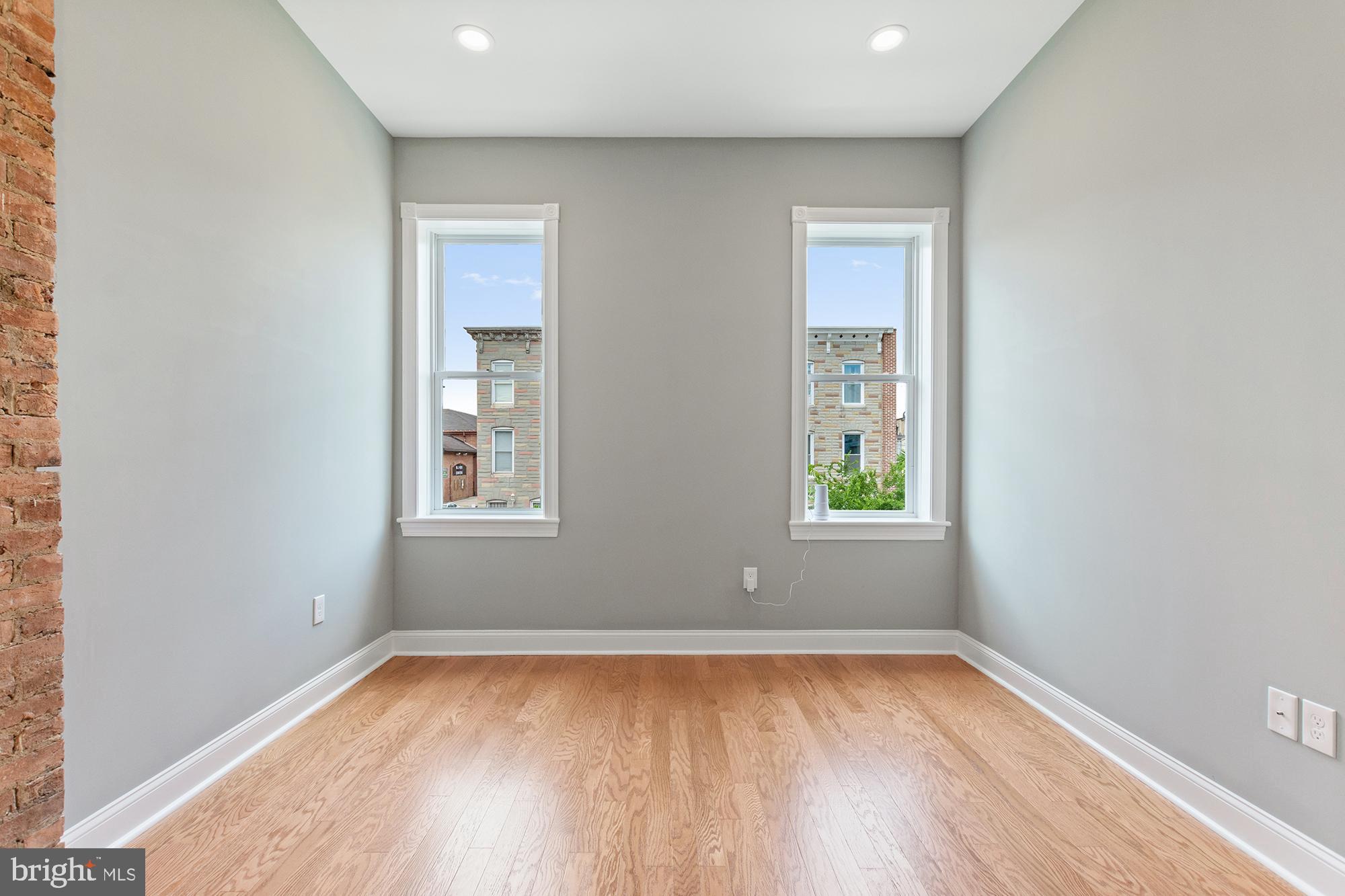 1433 Federal Street Baltimore, MD 21213 - Photo 9 of 9 an empty room with wooden floor and windows