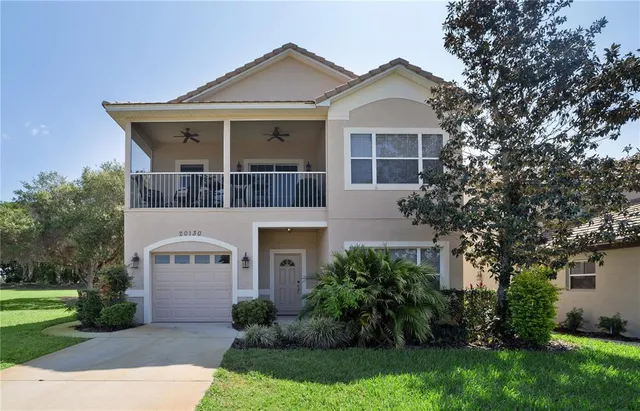 a front view of a house with a yard and trees