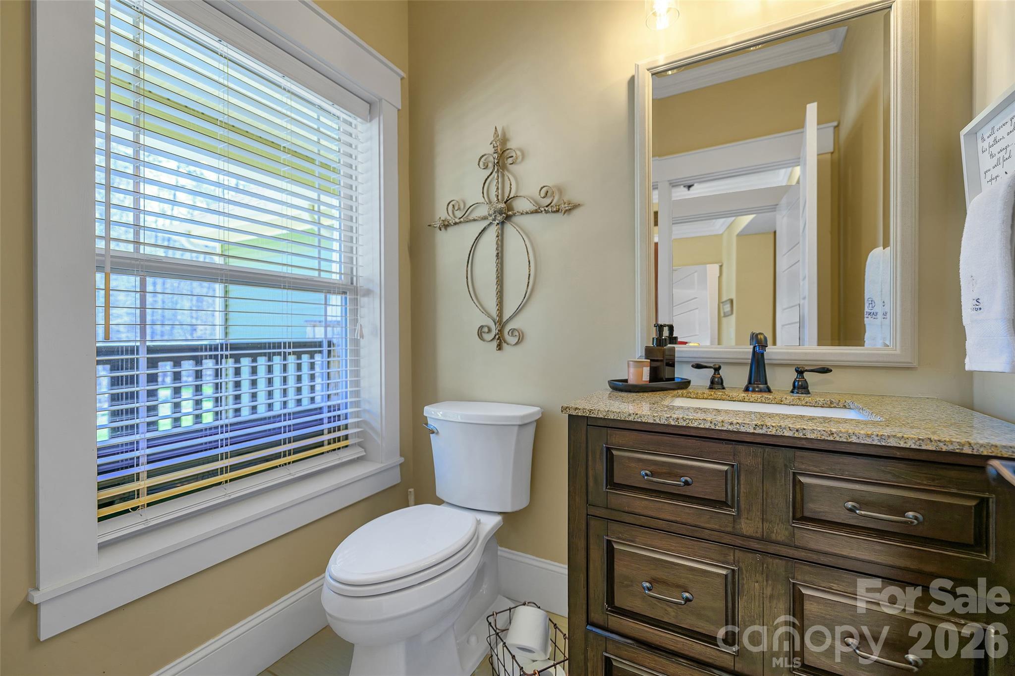 211 Holly Ridge Road Dallas, NC 28034 - Photo 21 of 46 a bathroom with a granite countertop toilet a sink and a mirror