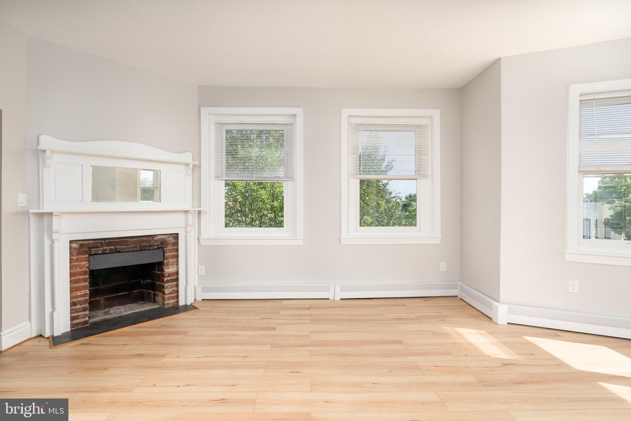 523 Constitution Avenue Northeast, Unit 3 Washington, DC 20002 - Photo 3 of 16 a view of empty room with wooden floor fireplace and windows