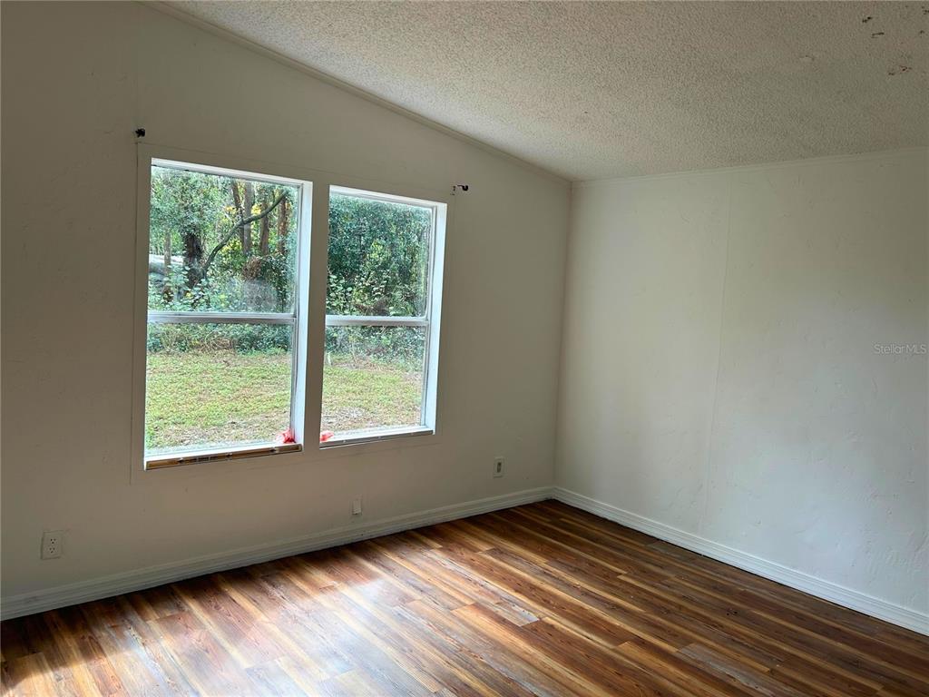 9867 Jerome Drive New Port Richey, FL 34654 - Photo 19 of 30 a view of an empty room with wooden floor and a window