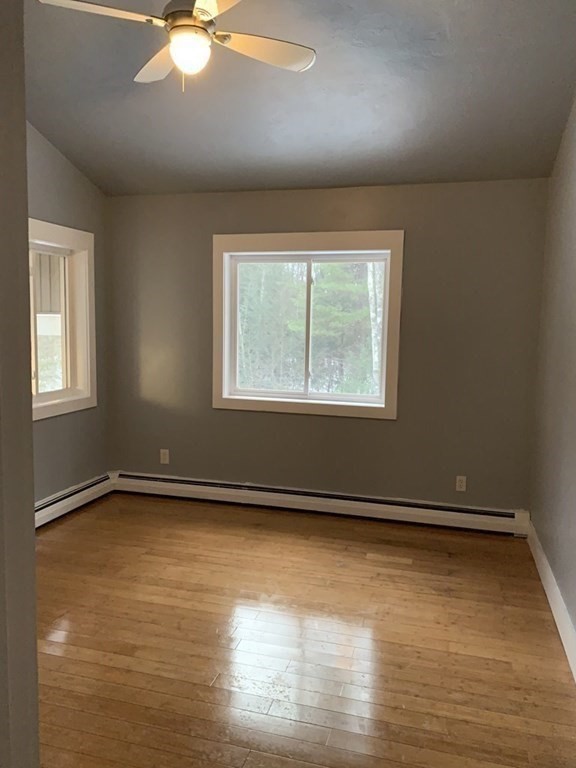 105 Sand Hill Road Shutesbury, MA 01072 - Photo 11 of 30 an empty room with wooden floor and windows