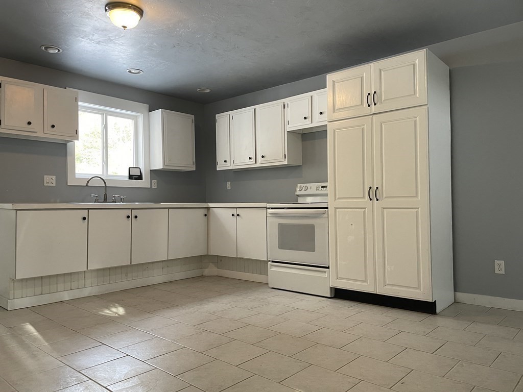105 Sand Hill Road Shutesbury, MA 01072 - Photo 14 of 30 a kitchen with granite countertop white cabinets and white appliances