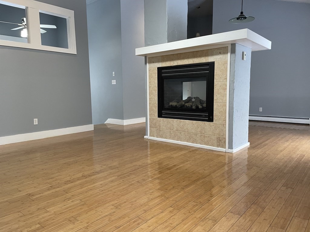 105 Sand Hill Road Shutesbury, MA 01072 - Photo 5 of 30 a view of a livingroom with wooden floor and a fireplace