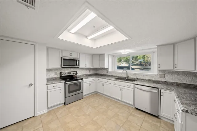 a kitchen with stainless steel appliances granite countertop a sink and a stove