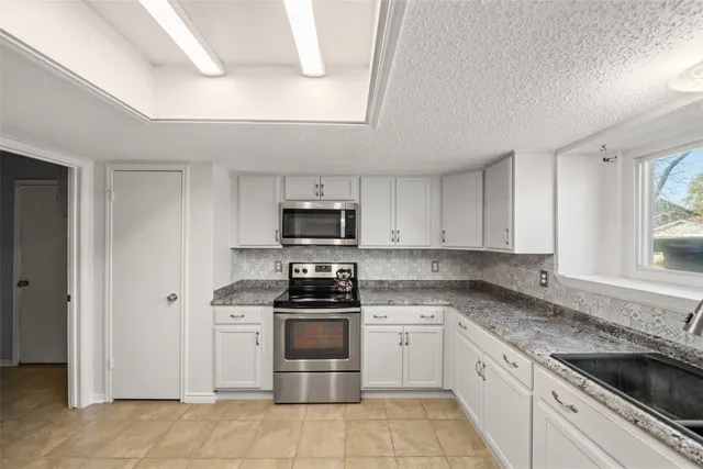 a kitchen with a sink stove top oven and cabinets