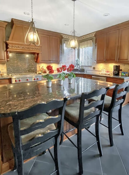 1408 Mink Trail Cary, IL 60013 - Photo 13 of 34 a kitchen with granite countertop kitchen island stainless steel appliances a table chairs sink and stove top oven