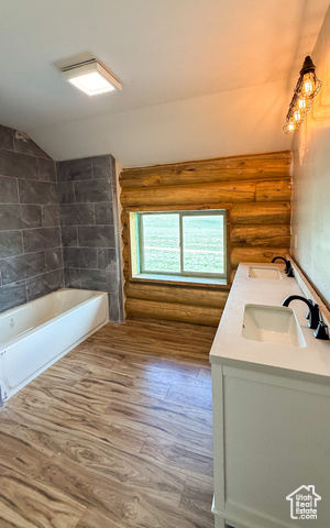 5236 North Holly Way Helper, UT 84526 - Photo 14 of 34 Full bath featuring log walls, double vanity, wood finished floors, lofted ceiling, and bathing tub / shower combination