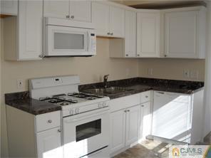 227 Washington Road Sayreville, NJ 08872 - Photo 5 of 16 a kitchen with stainless steel appliances granite countertop white cabinets and a stove
