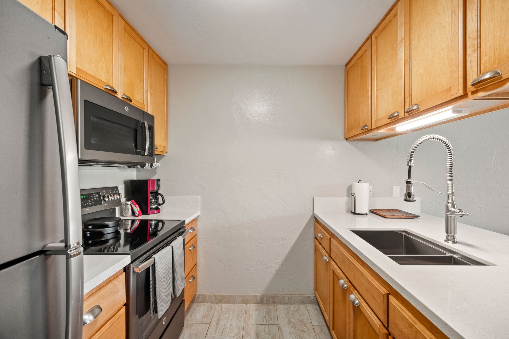 525 Aleka Loop, Unit H7 Kapaa, HI 96746 - Photo 9 of 30 a kitchen with stainless steel appliances a sink stove top oven and cabinets