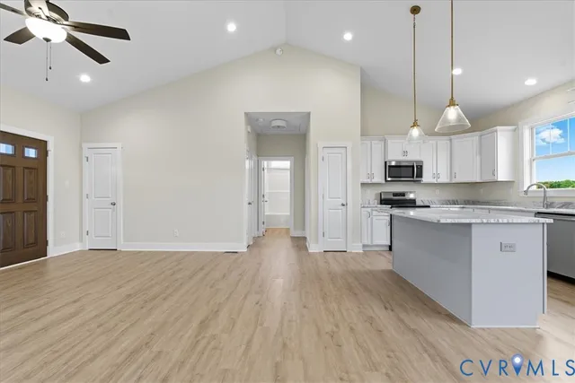 a large kitchen with cabinets a sink and stainless steel appliances