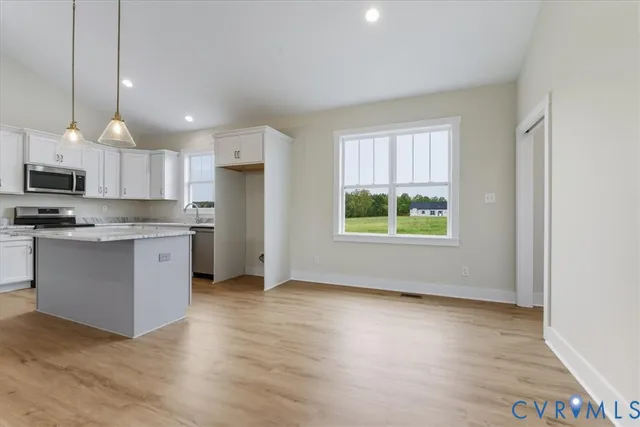 a kitchen with stainless steel appliances granite countertop a stove a sink a refrigerator and a microwave