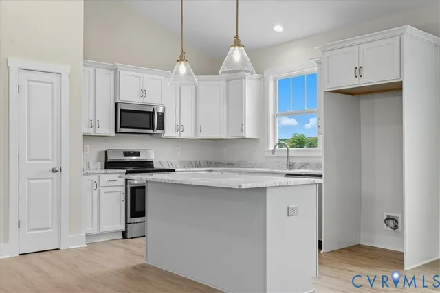 a kitchen with kitchen island granite countertop a stove a sink a refrigerator and a microwave