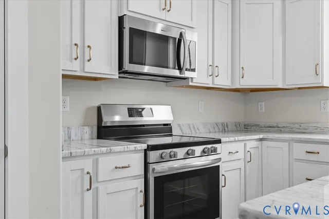 a kitchen with granite countertop white cabinets and appliances