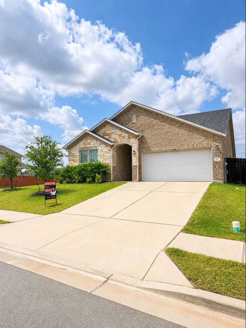 693 Durian Loop Buda, TX 78610 - Photo 2 of 27 A well-maintained lawn and sturdy brick and stone facade welcome you to this inviting property.
