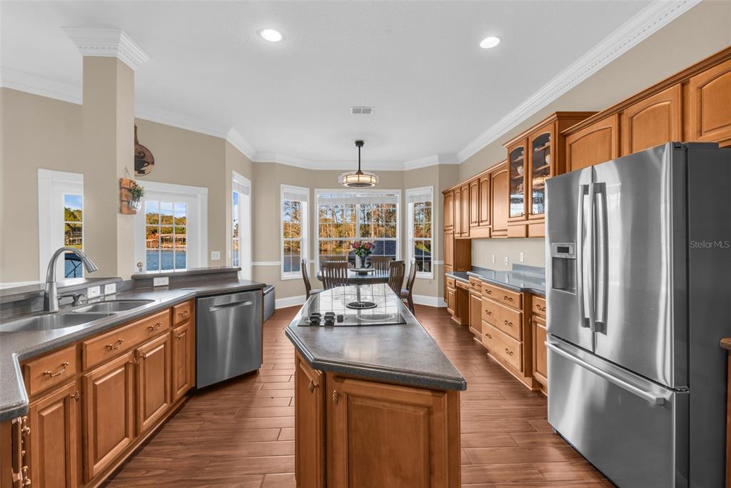1425 Riviera Drive Kissimmee, FL 34744 - Photo 16 of 82 a kitchen with stainless steel appliances granite countertop a refrigerator a sink dishwasher a stove and white countertops with wooden floor