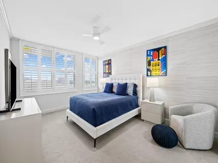 a bedroom with a bed a couch and a large window