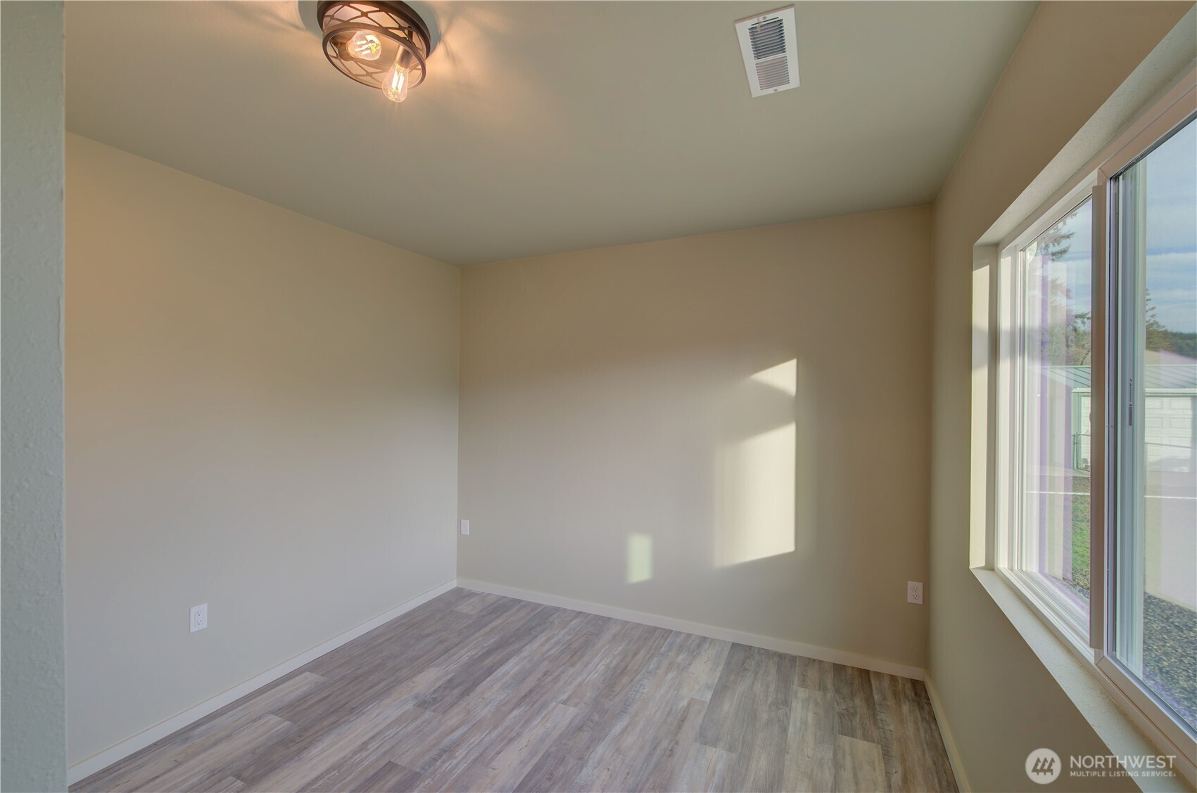 1365 Dolan Street Raymond, WA 98577 - Photo 14 of 24 an empty room with wooden floor and windows
