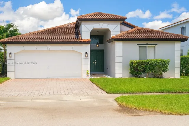 a front view of a house with a garden and garage