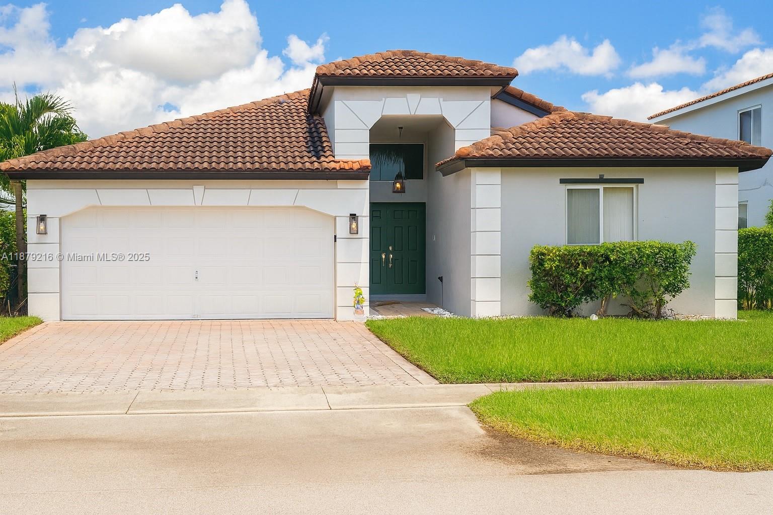 13221 Southwest 53rd Street Miramar, FL 33027 - Photo 1 of 24 a front view of a house with a garden and garage
