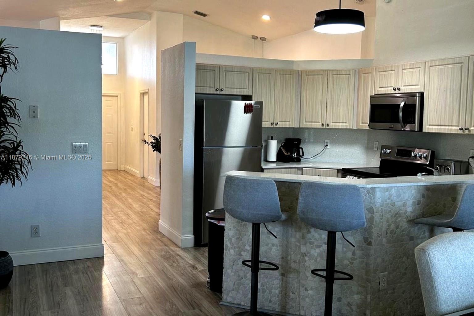 13221 Southwest 53rd Street Miramar, FL 33027 - Photo 11 of 24 a kitchen with stainless steel appliances granite countertop a refrigerator a stove top oven a sink and dishwasher