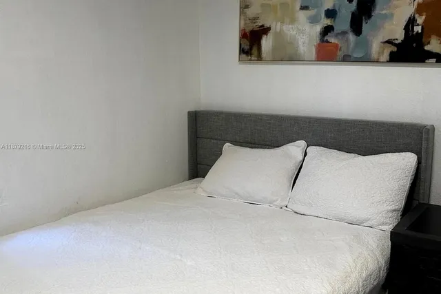 a large bed sitting in a bedroom next to a wall
