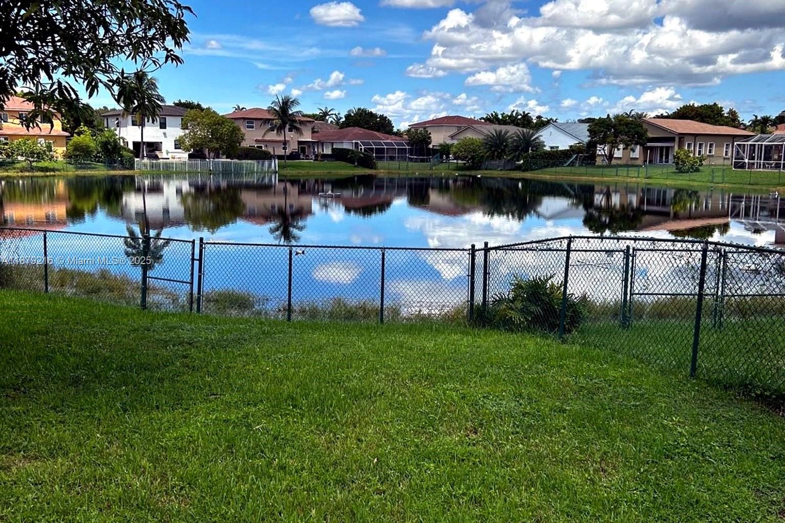 13221 Southwest 53rd Street Miramar, FL 33027 - Photo 4 of 24 a view of a lake with a house in the background