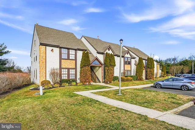 a view of a big building with a big yard and large trees