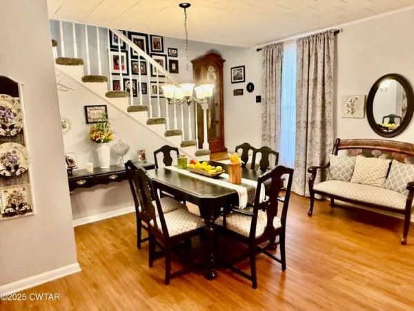 a dining room with furniture a chandelier and wooden floor