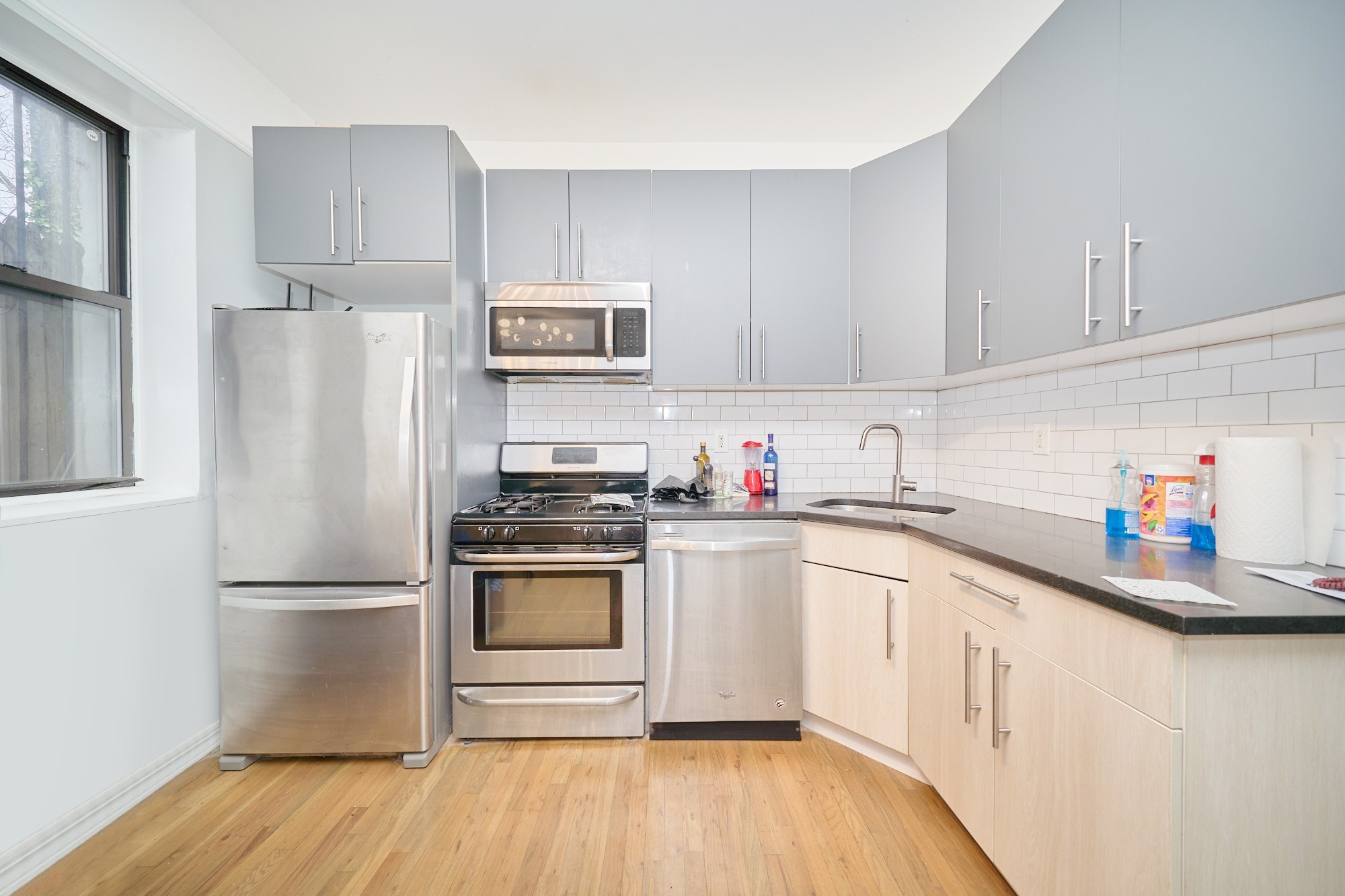 459 Sterling Place, Unit 3 Brooklyn, NY 11238 - Photo 3 of 7 a kitchen with granite countertop a refrigerator stove and white cabinets