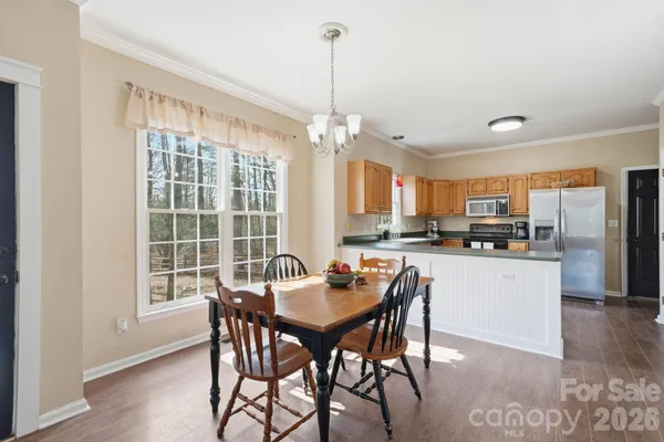 a kitchen with stainless steel appliances kitchen island granite countertop a dining table chairs and granite counter tops