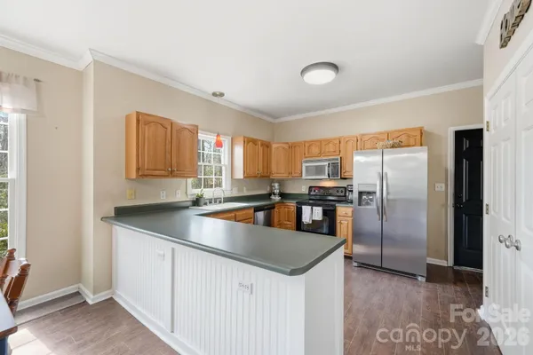 a kitchen with stainless steel appliances granite countertop a sink a stove and a refrigerator