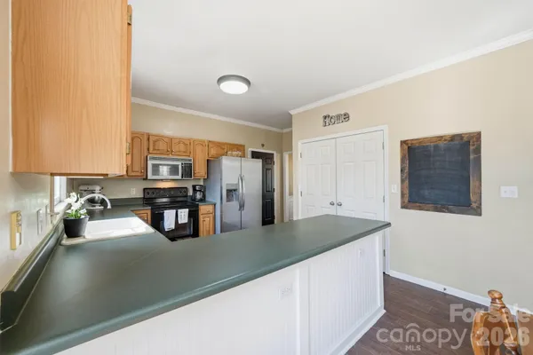 a kitchen with stainless steel appliances granite countertop a sink a stove counter space and cabinets