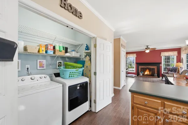 a utility room with dryer washer and a fireplace