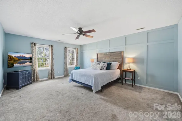 a spacious bedroom with a bed and a chandelier