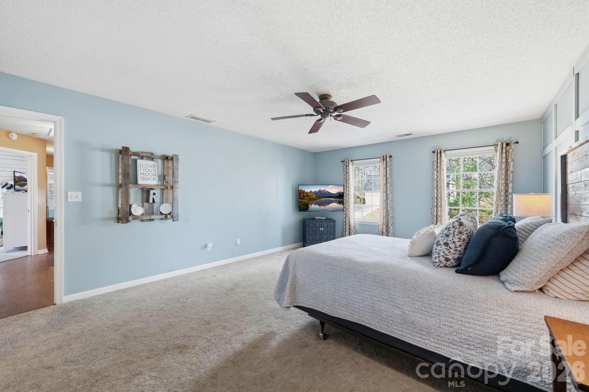 242 Windsor Forest Circle Fletcher, NC 28732 - Photo 23 of 43 a bedroom with a large bed and a chandelier