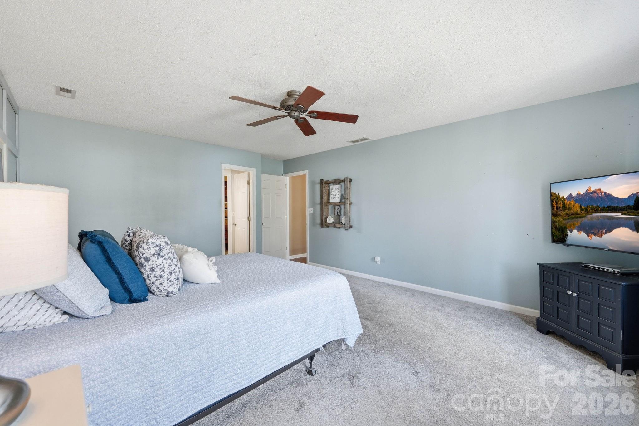 242 Windsor Forest Circle Fletcher, NC 28732 - Photo 24 of 43 a bedroom with a bed and a chandelier